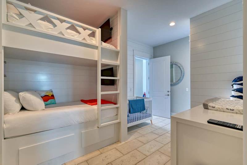 Ground level bedroom features twin bunks and a crib.