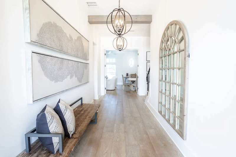 Hallway from front door entrance leads to downstairs living space, laundry room, bathroom, and 3 bedrooms.