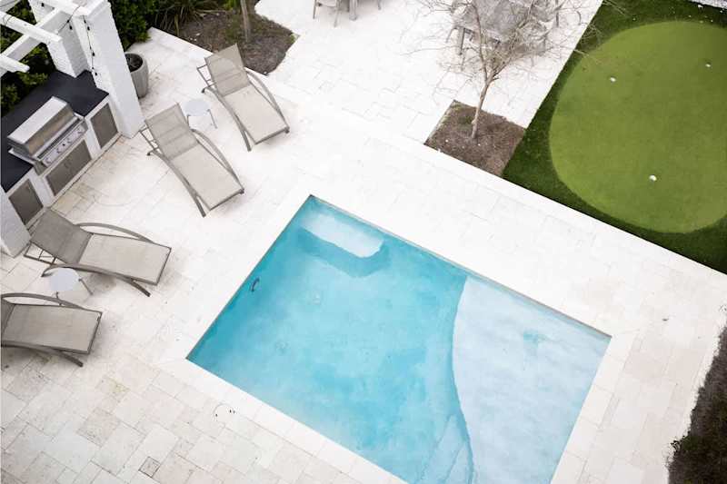 Heated pool features a tanning shelf.