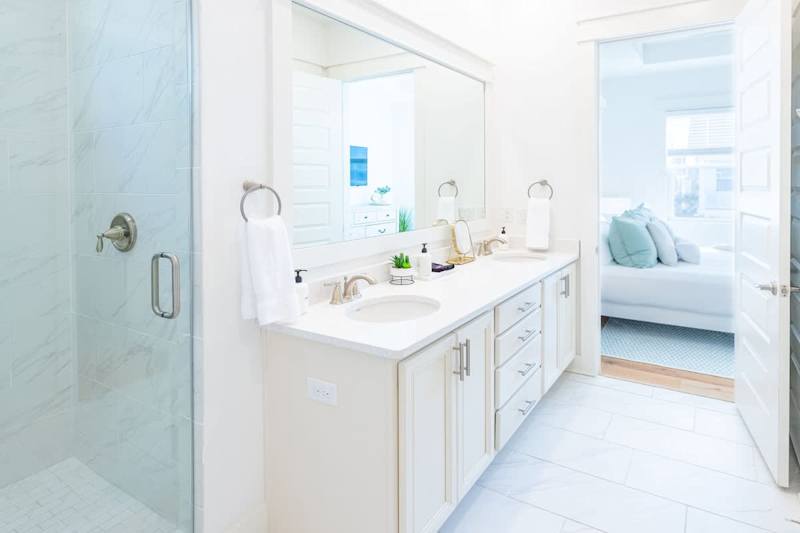 Primary bathroom with dual vanities and large walk-in shower.