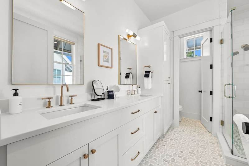 Bathroom features dual vanities, a walk-in shower and soaker tub.