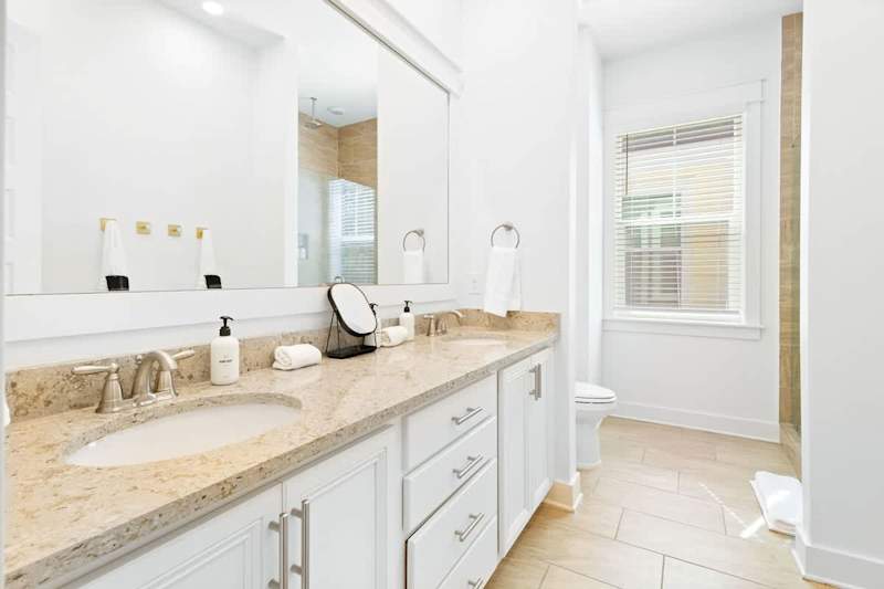 Bathroom features dual vanities and walk-in shower.