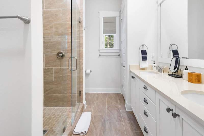 Bathroom features dual vanities and walk-in shower.