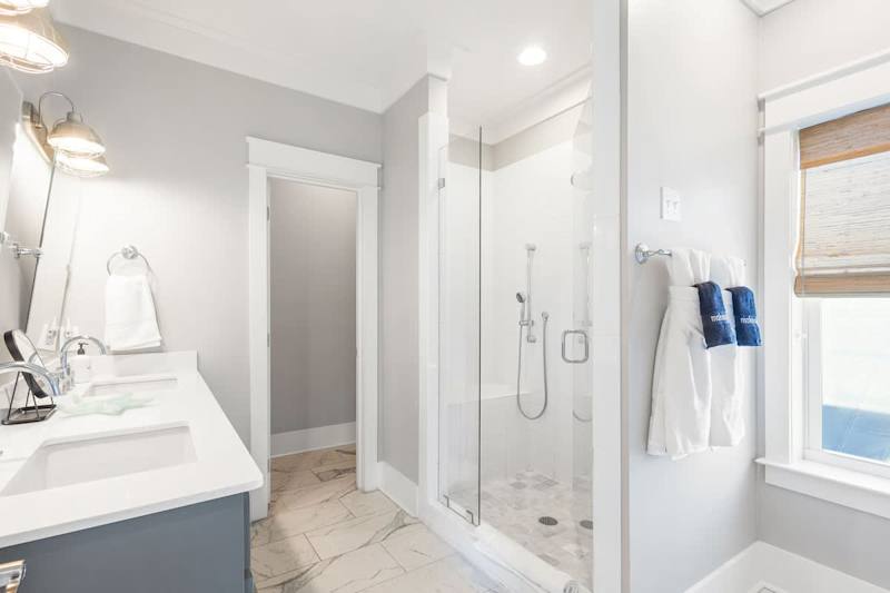 Bathroom features dual vanities and walk-in shower.