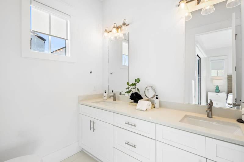 Bathroom features dual vanities and a walk-in shower.