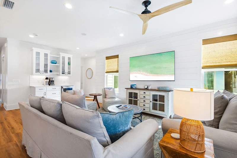 Living room features plenty of seating and a smart tv.