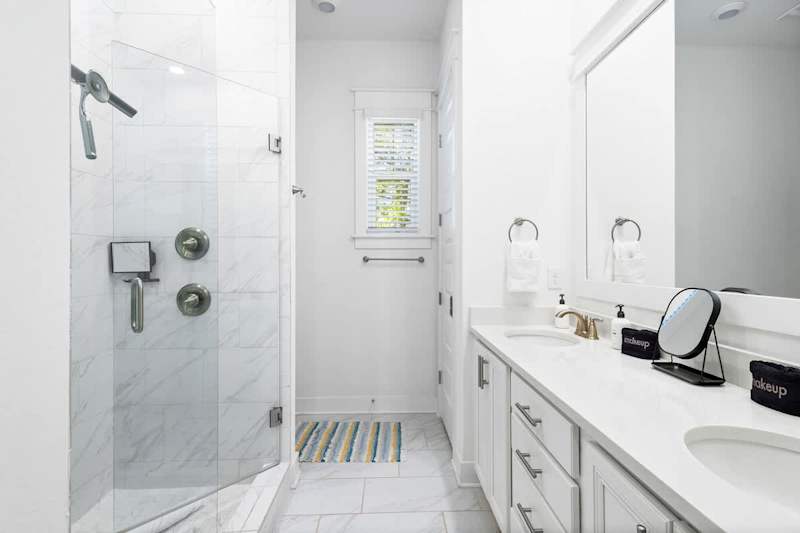 Bathroom features dual vanities and a walk0in shower.