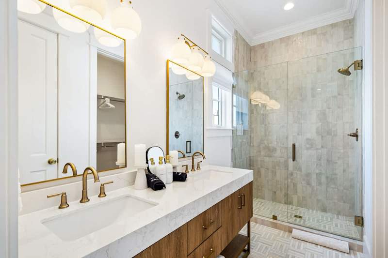 Bathroom features dual vanities and a large walk-in shower.