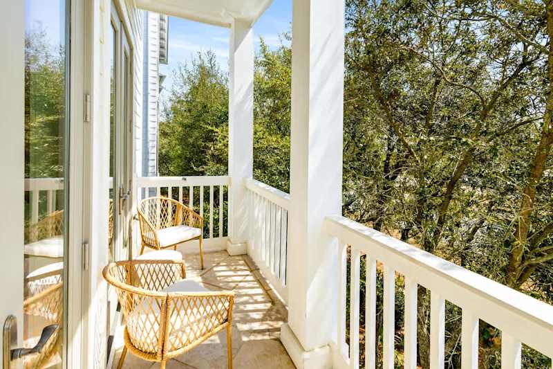 Outdoor balcony off living room includes two seating areas.