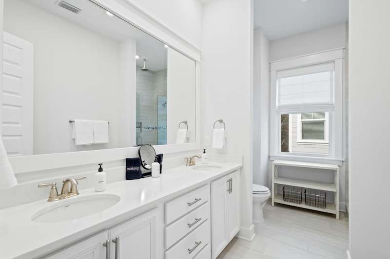 Bathroom features dual vanities and a walk-in shower.