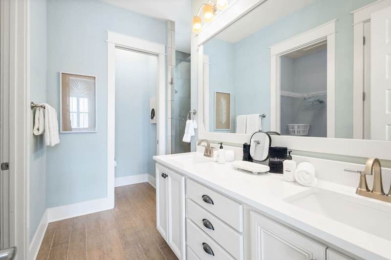Bathroom features a large walk-in closet, dual vanities and a walk-in shower.
