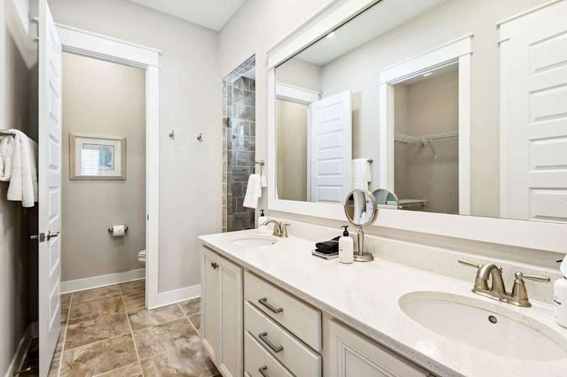 Bathroom features a large walk-in closet, dual vanities and a walk-in shower.