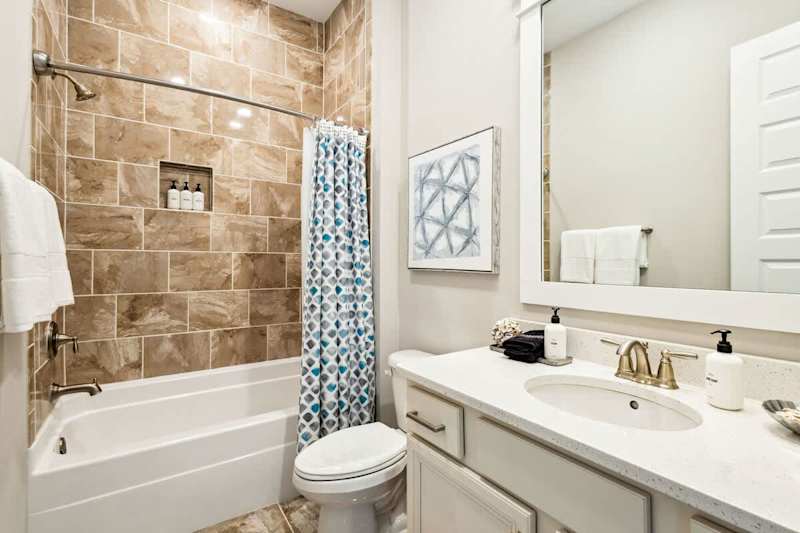 Guest bathroom features a shower/tub combo.