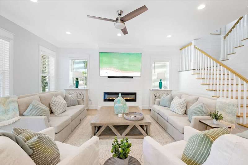 Living room includes plenty of seating for all, including rocking swivel chairs for lounging.