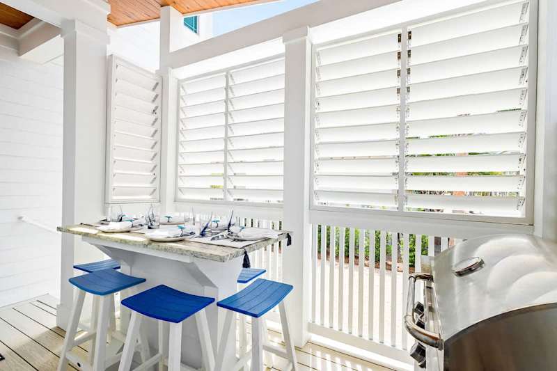 Covered back deck includes a gas grill and seating for six.