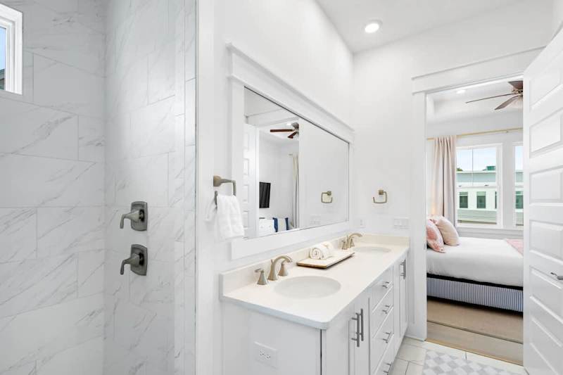 Bathroom features dual vanities and a large walk-in shower.