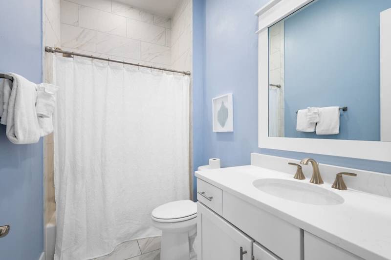 Guest bathroom features a shower/tub combo.