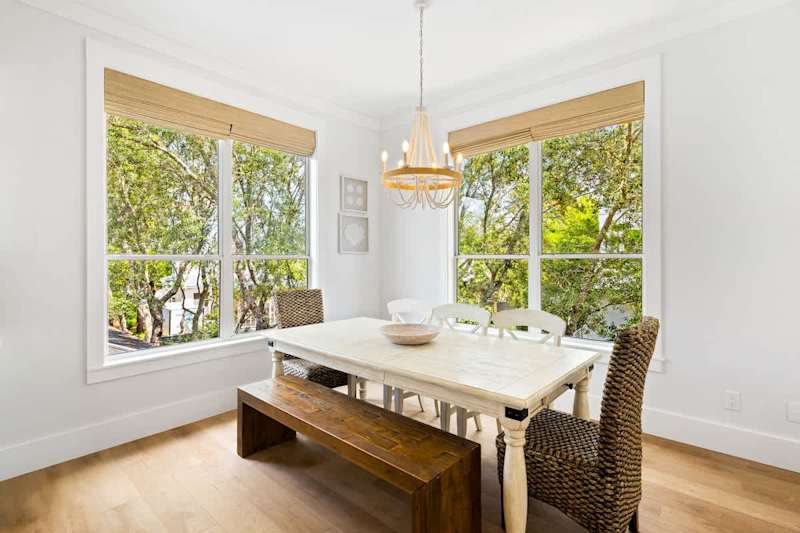 Dining room table includes seating for 6 and features large windows bringing in natural light.