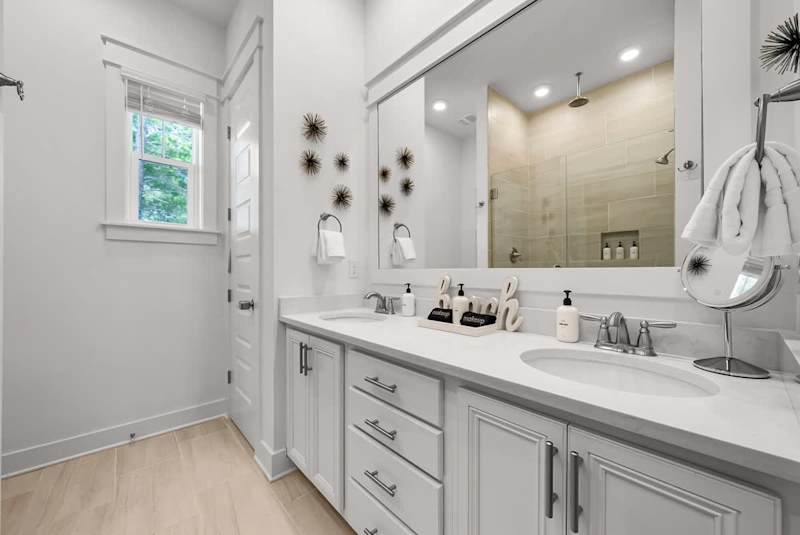 Bathroom features dual vanities and walk-in shower.