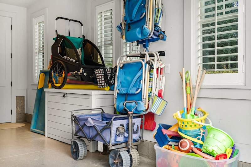 Garage is packed with essentials for the beach with beach chairs, coolers, beach toys, wagon, umbrellas