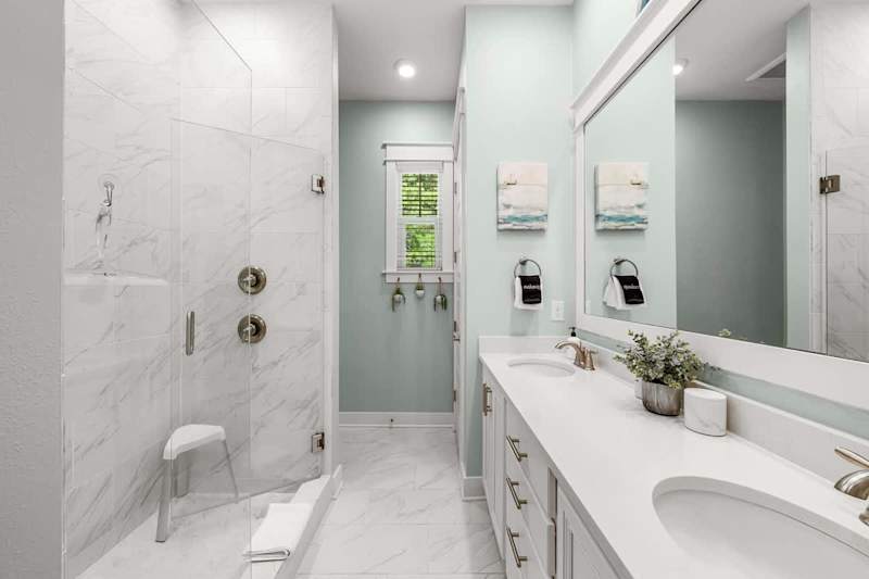 Bathroom features dual vanities and walk-in shower.