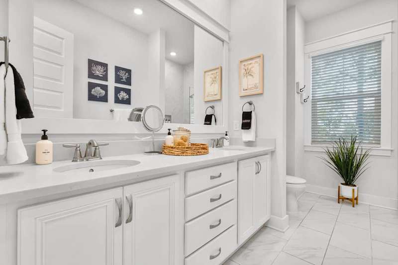 Bathroom features dual vanities and walk-in shower.