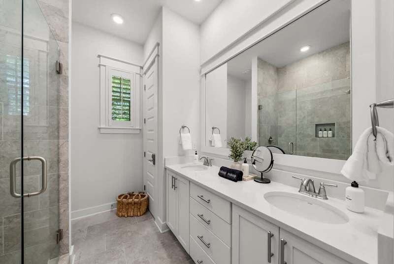Bathroom features dual vanities and walk-in shower.