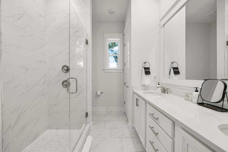 Bathroom features dual vanities and walk-in shower.