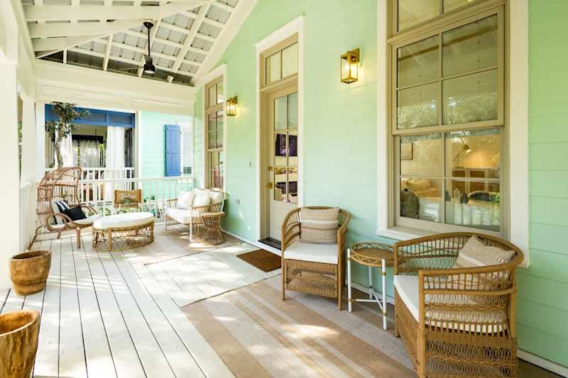 Covered front porch features seating & dining area.