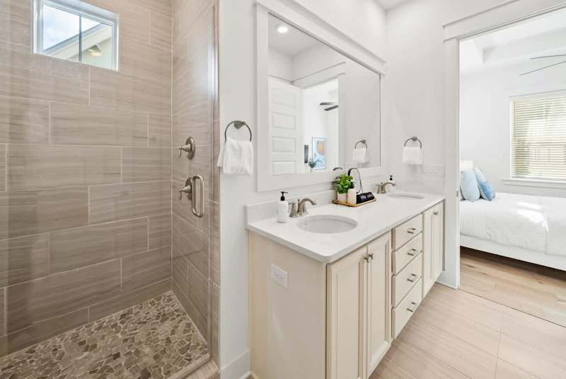 Bathroom with dual vanities and large walk-in shower.
