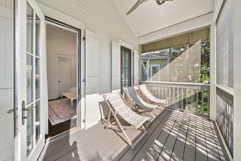 Bedroom includes a large screened-in private balcony with seating.