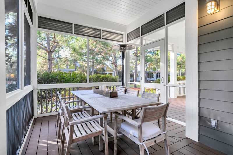 Screened-in front porch incudes a dining table with seating for 8.