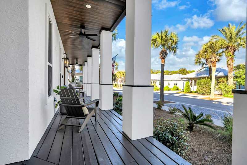 Expansive front porch includes multiple seating options.