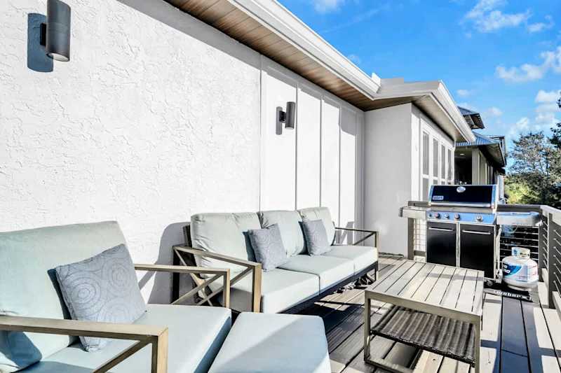 Back balcony features seating and a gas grill.