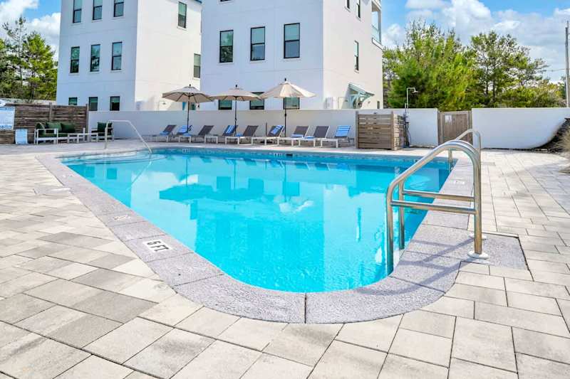 Unwind at the large heated communal pool, offering abundant lounge chairs for your comfort.