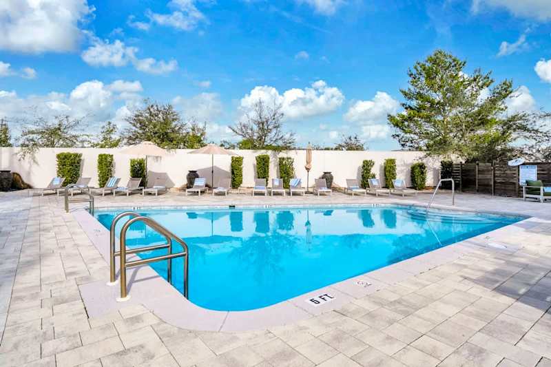 Unwind at the large heated communal pool, offering abundant lounge chairs for your comfort.