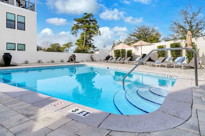 Heated community pool with lounge chairs and outdoor seating