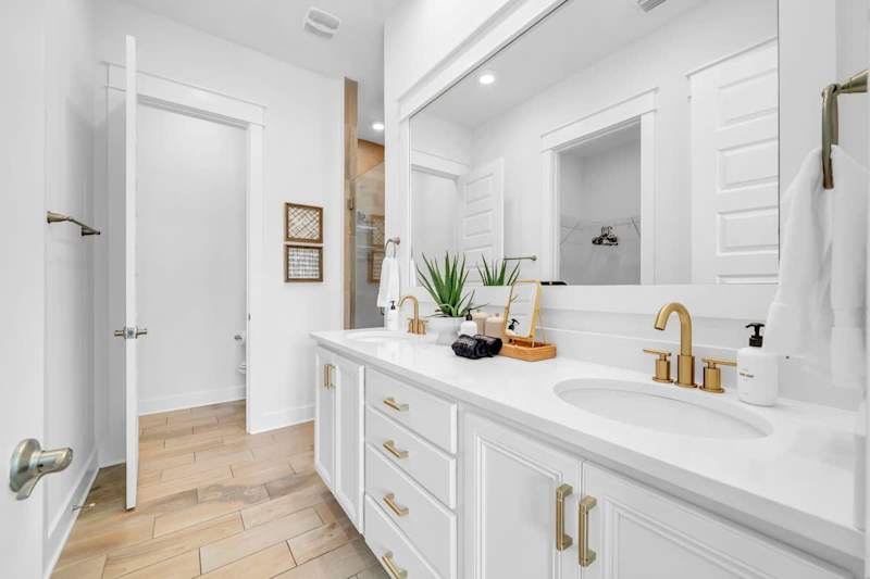 Primary bathroom comes equipped with dual vanities, walk-in closet, and walk-in shower.
