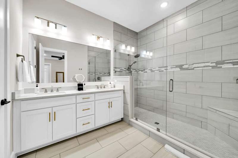Bathroom has dual sinks and large walk-in shower.