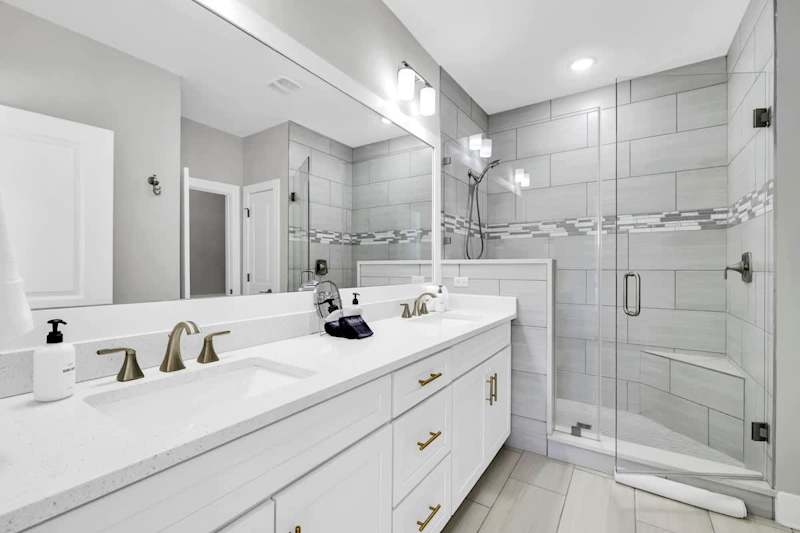 Bathroom has dual sinks and large walk-in shower