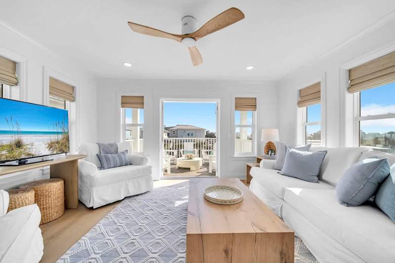 Third floor living space with smart tv and access to private deck with seating.