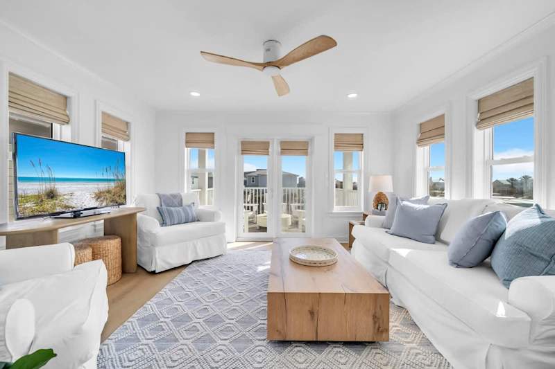 Third floor living space with smart tv and access to private deck with seating