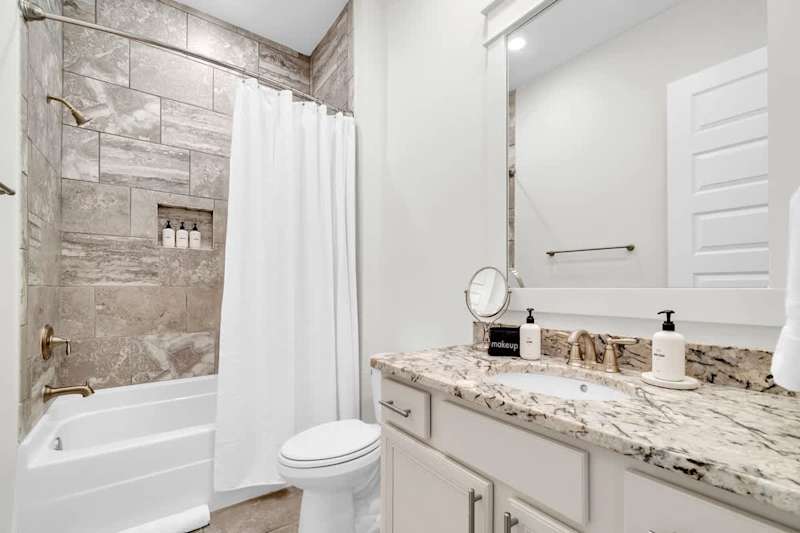 Guest bathroom features a shower/tub combo.