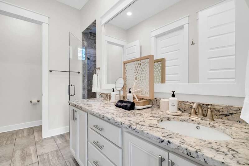 Primary bathroom features a large walk-in closet, dual vanities and a large walk-in shower.