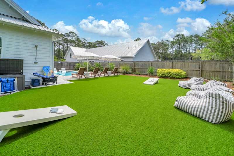 Backyard green space with corn hole and bean bag chairs