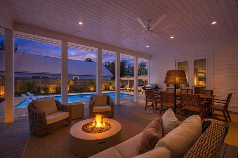 Outdoor covered patio with seating, smart tv, grill, and firepit.