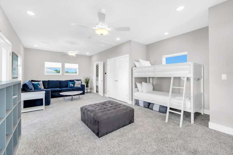 Third floor loft space features double/double bunk, sleeper sofa, & smart tv. Along with balcony access and seating.