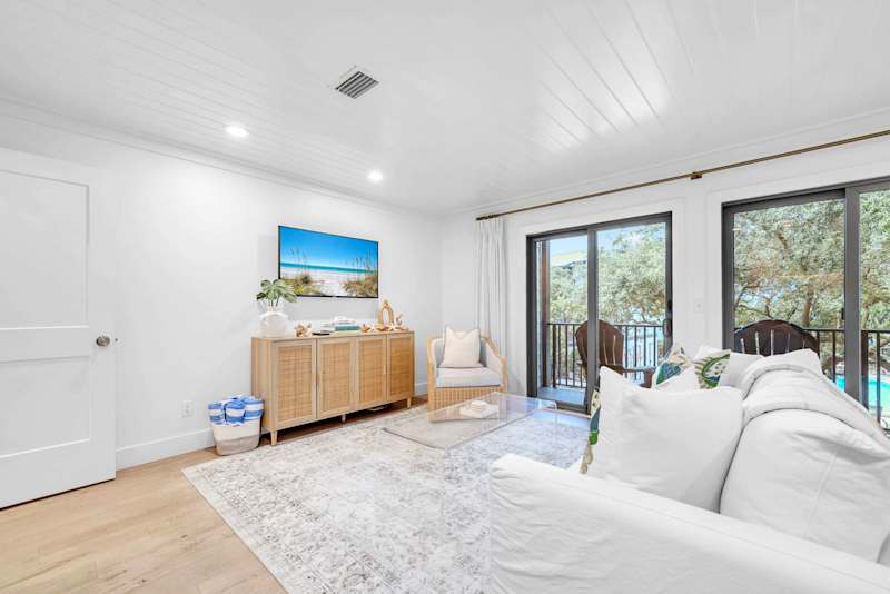 Living room features a sleeper sofa, smart tv, and access to balcony