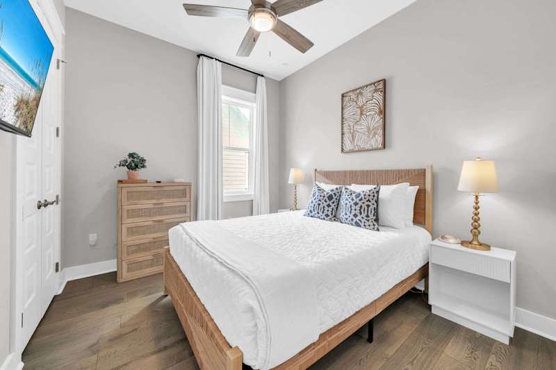 Guest bedroom features a queen with smart tv