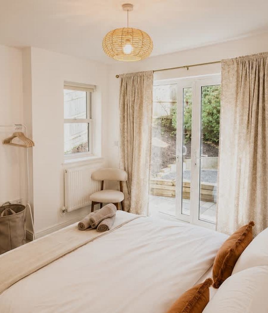 A bright bedroom with doors to the garden in our Bath home